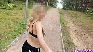 Blondínka cvičí vonku v parku, odhaľuje svoje nahé telo a poskakuje prsiami